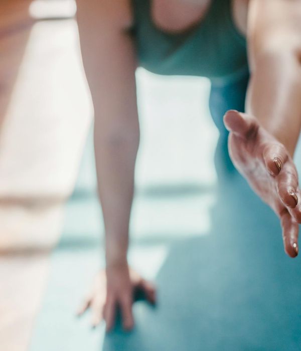 Woman in a serene yoga pose in a light, airy room.